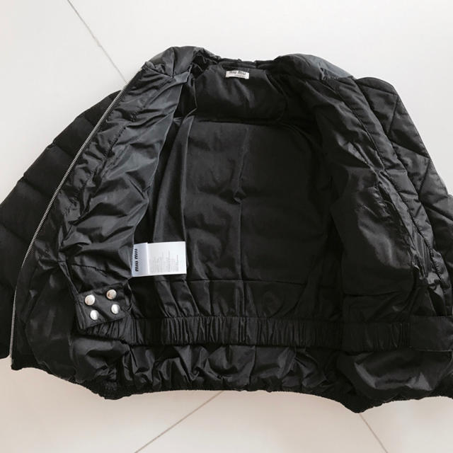 miumiu(ミュウミュウ)のミュウミュウ 正規品 ロゴ入り未使用フリルダウンジャケット 黒 miumiu レディースのジャケット/アウター(ダウンジャケット)の商品写真