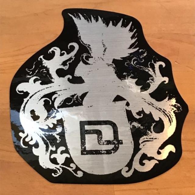 DEELUXE(ディーラックス)のDEELUXE ディーラックス メタル紋章ステッカー 銀/黒 16cm スポーツ/アウトドアのスノーボード(アクセサリー)の商品写真