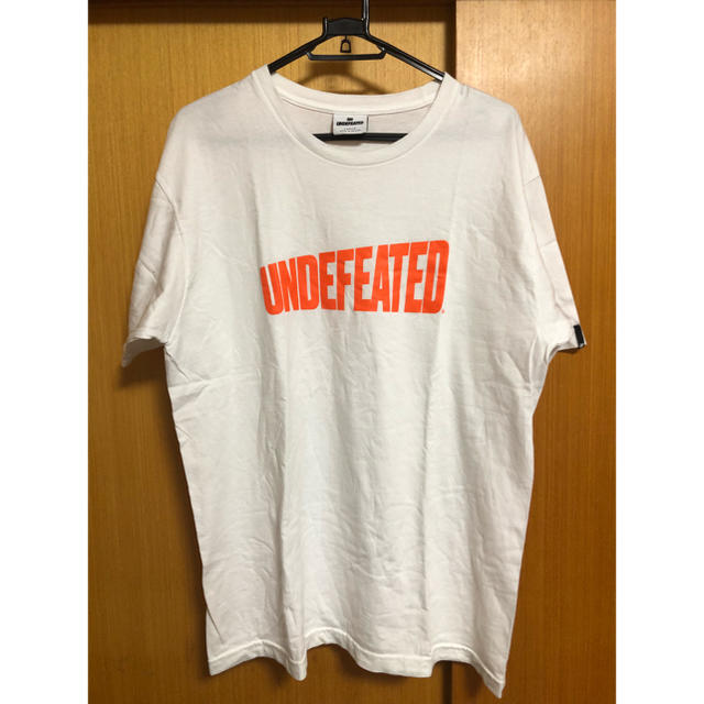 UNDEFEATED(アンディフィーテッド)のUNDEFEATED Tシャツ オレンジ ロゴ アンディフィーテッド メンズのトップス(Tシャツ/カットソー(半袖/袖なし))の商品写真