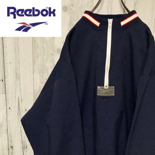 リーボック(Reebok)のリーボック ビッグロゴ スケルトン PVC ハーフジップ ナイロンジャケット(ナイロンジャケット)