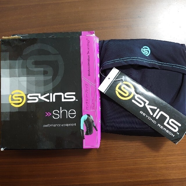 SKINS(スキンズ)の【新品】スキンズ SKINS >>She ロングスリーブ　トップ  女性用 XS スポーツ/アウトドアのトレーニング/エクササイズ(トレーニング用品)の商品写真
