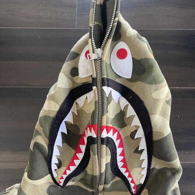 A BATHING APE(アベイシングエイプ)のAPE BAPE KAWS camo 迷彩　シャーク　パーカー　L メンズのトップス(パーカー)の商品写真