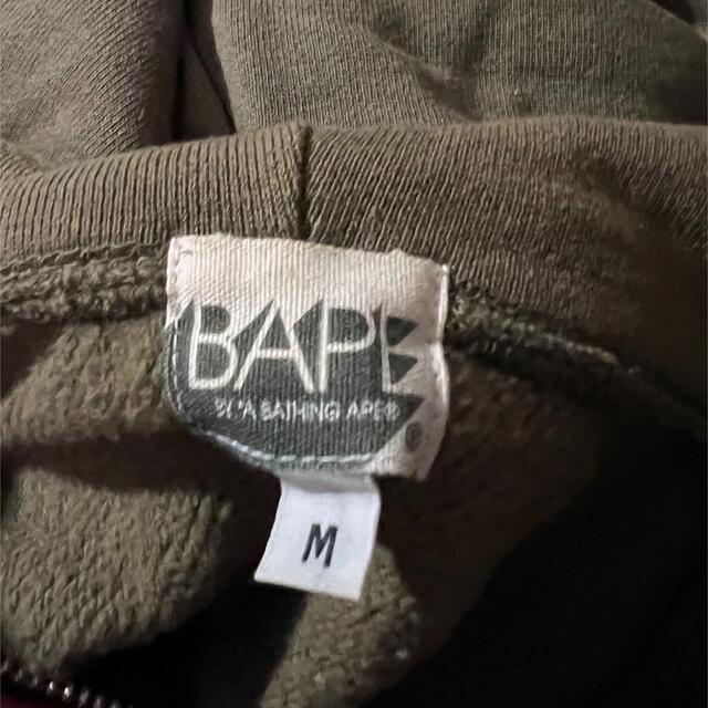 A BATHING APE(アベイシングエイプ)のA BATHING APE KAWS パーカー コラボ 歯型 カーキ オリーブ メンズのトップス(パーカー)の商品写真