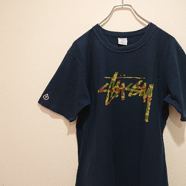 STUSSY(ステューシー)の《コラボ》Champion×STUSSY 迷彩ロゴ ネイビー メンズのトップス(Tシャツ/カットソー(半袖/袖なし))の商品写真