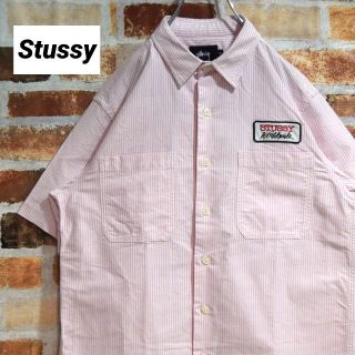 ステューシー(STUSSY)の《ステューシー》刺繍ブランドロゴ　ピンク系ストライプ　Mサイズ　ワークシャツ(シャツ)