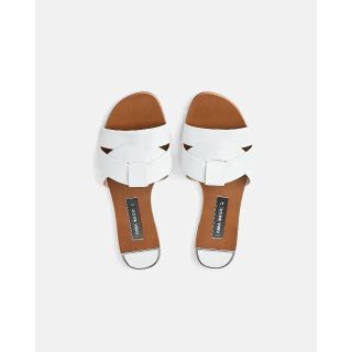 ザラ(ZARA)の【新品未使用】ZARA ザラ クロスオーバーレザーサンダル白  フラットサンダル(サンダル)