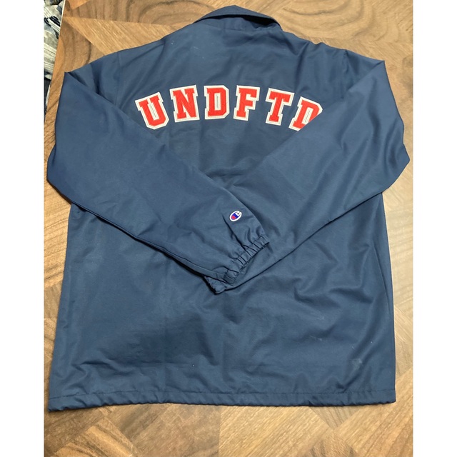 UNDEFEATED(アンディフィーテッド)のアンディフィーテッド　チャンピオン　ナイロンジャケット　Mサイズ　ネイビー メンズのジャケット/アウター(ナイロンジャケット)の商品写真