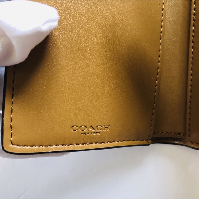 COACH(コーチ)のコーチシグネチャー×ホワイト小銭入れ付き三つ折り財布　ロゴバックル レディースのファッション小物(財布)の商品写真
