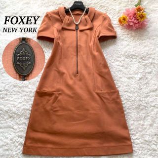 フォクシー(FOXEY)の【美品】FOXEY NEW YORK  ポロクラバット　ロゴファスナー　オレンジ(ひざ丈ワンピース)