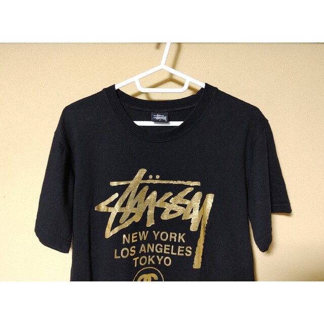 STUSSY(ステューシー)のSTUSSY＊Tシャツ・半袖・サイズＬ＊両面プリントロゴ入り・ブラック・ゴールド レディースのトップス(Tシャツ(半袖/袖なし))の商品写真