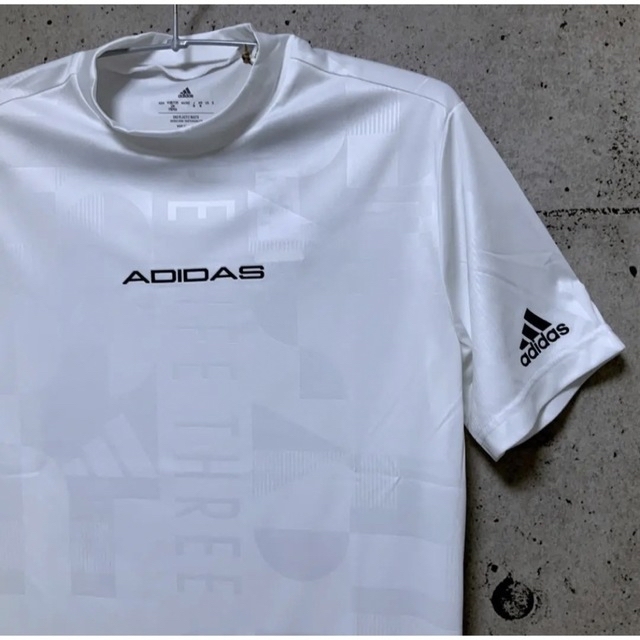 adidas(アディダス)のアディダスゴルフ【L】エンボスプリント 半袖モックネックシャツ（白） スポーツ/アウトドアのゴルフ(ウエア)の商品写真