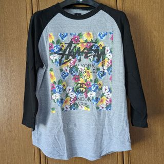 ステューシー(STUSSY)のSTUSSY 花柄　ワールドツアー　7分袖Tシャツ　L 灰色　黒色　ステューシー(Tシャツ/カットソー(七分/長袖))