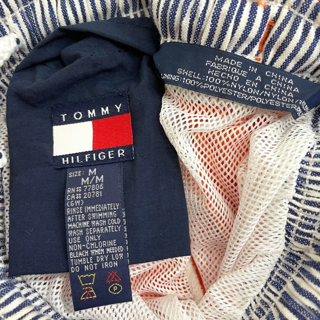 US古着 トミーヒルフィガー TOMMY HILFIGER ナイロン スイム ショートパンツ ボードショーツ クレイジーパターン ロゴ パッチ ひざ上 サイズ：W25～ オレンジ×レッド×ホワイト×ネイビー  【中古】 メンズのスーツ(スラックス/スーツパンツ)の商品写真