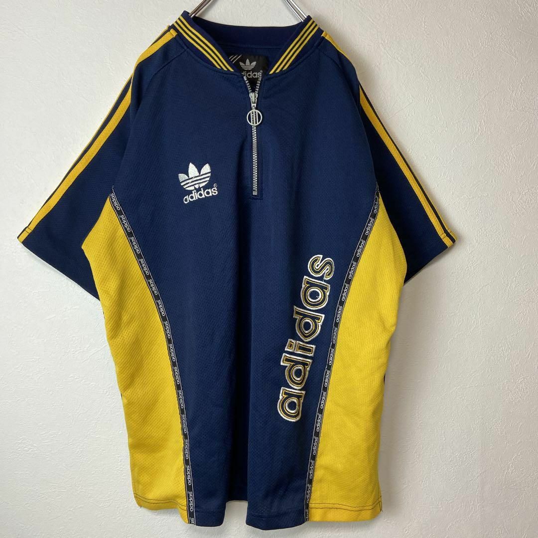 ハーフジップ、ゲームシャツ】adidasワンポイント刺繍ロゴ古着90s黄紺M