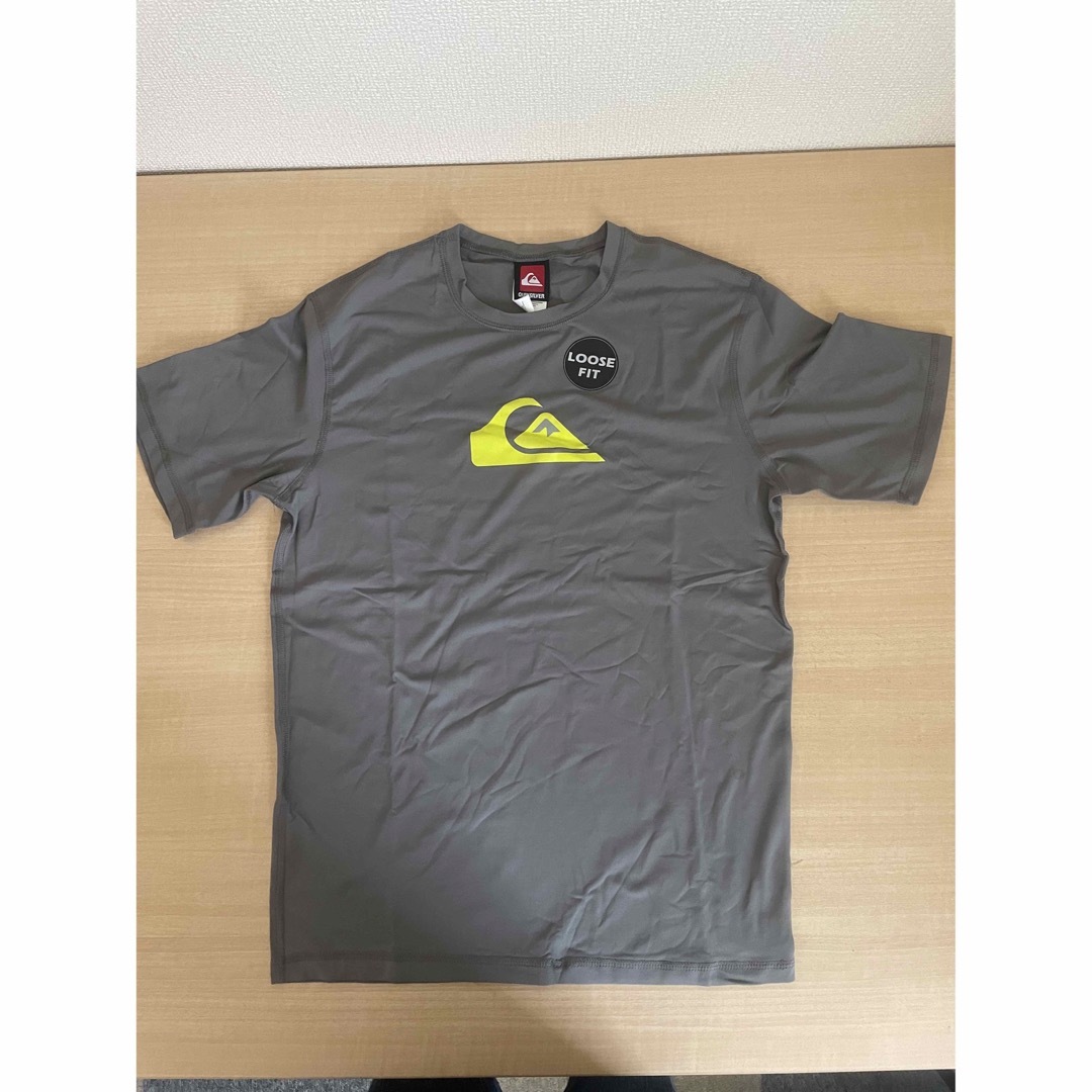 QUIKSILVER(クイックシルバー)の新品　クイックシルバー　半袖　ラッシュガード グレー　USサイズS スポーツ/アウトドアのスポーツ/アウトドア その他(サーフィン)の商品写真