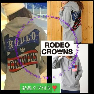 ロデオクラウンズワイドボウル(RODEO CROWNS WIDE BOWL)のRODEO リボンロゴ プリント パーカー ポケット国旗(パーカー)