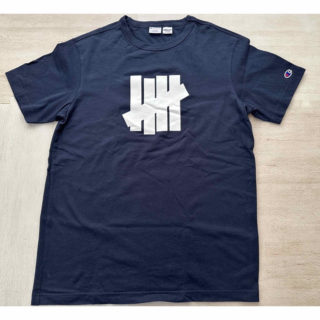 UNDEFEATED(アンディフィーテッド)のUNDEFEATED CHAMPION コラボ Tシャツ L メンズのトップス(Tシャツ/カットソー(半袖/袖なし))の商品写真