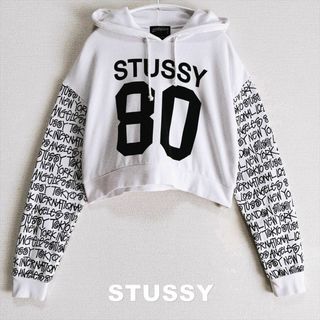 ステューシー(STUSSY)の【STUSSY】1980ロゴ ワールドツアーロゴスリーブ クロップ パーカー(パーカー)