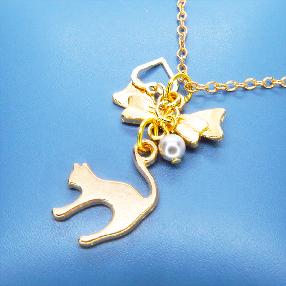 マットゴールド 跳ね猫とリボンのコンパクトなネックレス ガラスパール ハンドメイドのアクセサリー(ネックレス)の商品写真