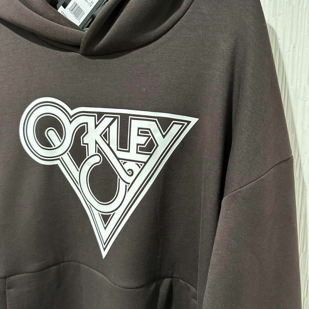 Oakley(オークリー)のOAKLEYオークリー スウェットパーカーブラウンスポーツウェア メンズM 新品 スポーツ/アウトドアのトレーニング/エクササイズ(トレーニング用品)の商品写真