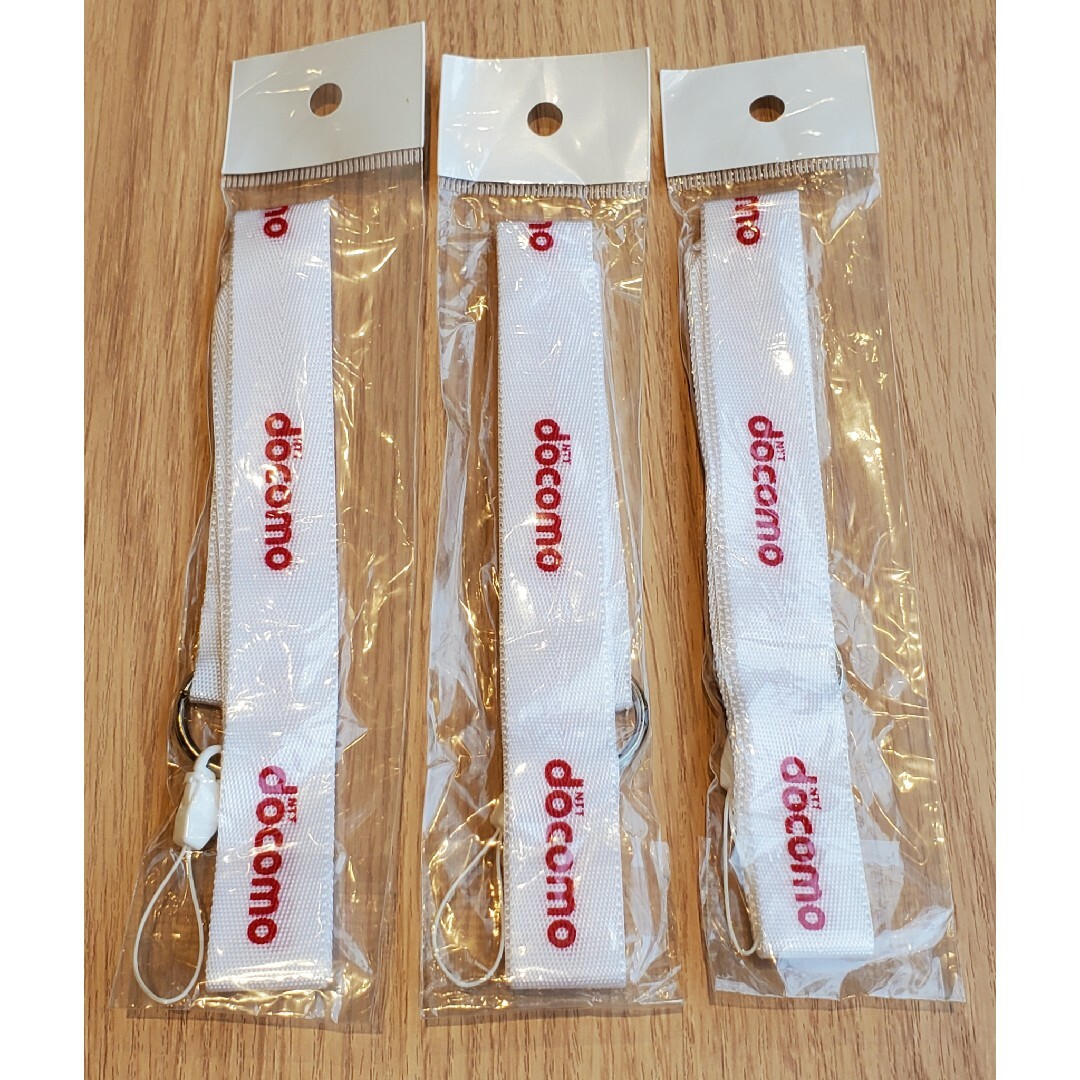 NTTdocomo(エヌティティドコモ)の3本組  NTTdocomo　ネックストラップ  ホワイト　レッド文字  非売品 エンタメ/ホビーのコレクション(ノベルティグッズ)の商品写真