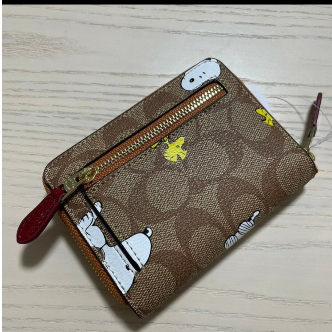 COACH(コーチ)の新品　COACH　二つ折り財布　スヌーピー　ディズニー　シグネチャー　小銭入れ有 レディースのファッション小物(財布)の商品写真