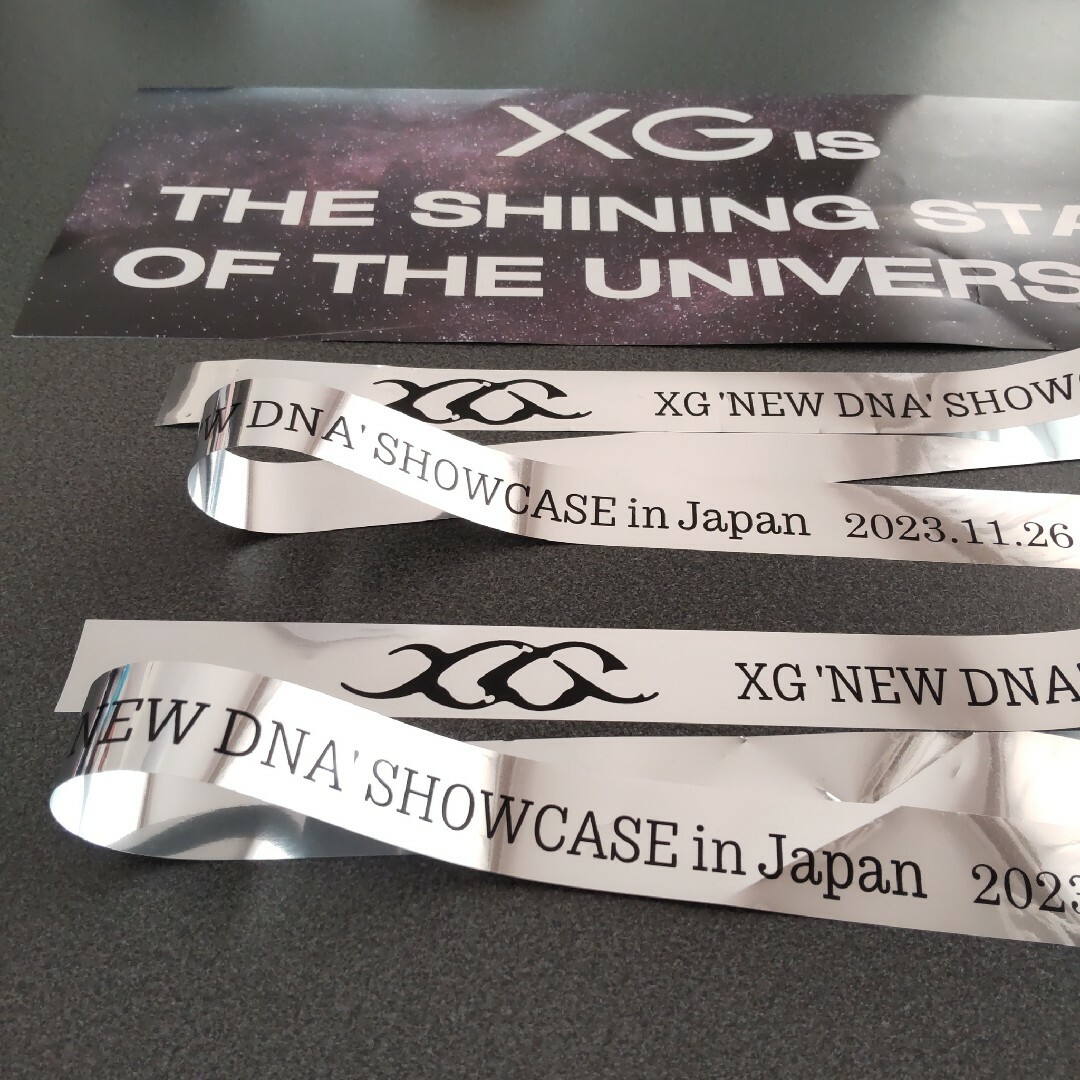 xg(エックスジー)のXG NEW DNA SHOWCASE  スローガン　銀テープ エンタメ/ホビーのタレントグッズ(アイドルグッズ)の商品写真