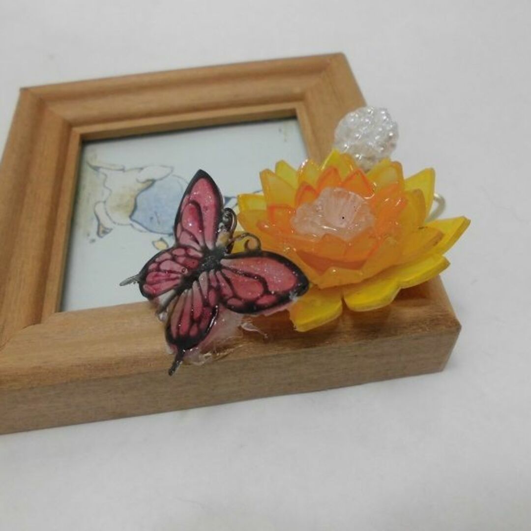 ミニフレームにレジンの蝶とプラ板のオレンジのお花を飾って インテリア/住まい/日用品のインテリア小物(フォトフレーム)の商品写真