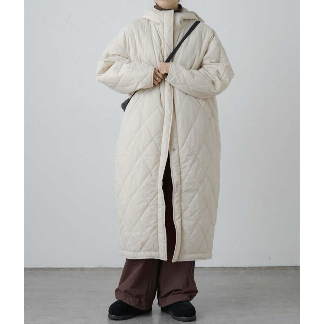 Omekashi(オメカシ)の新品タグ付き アーシー ナイロンリバーシブルキルティングコート アイボリー レディースのジャケット/アウター(ロングコート)の商品写真