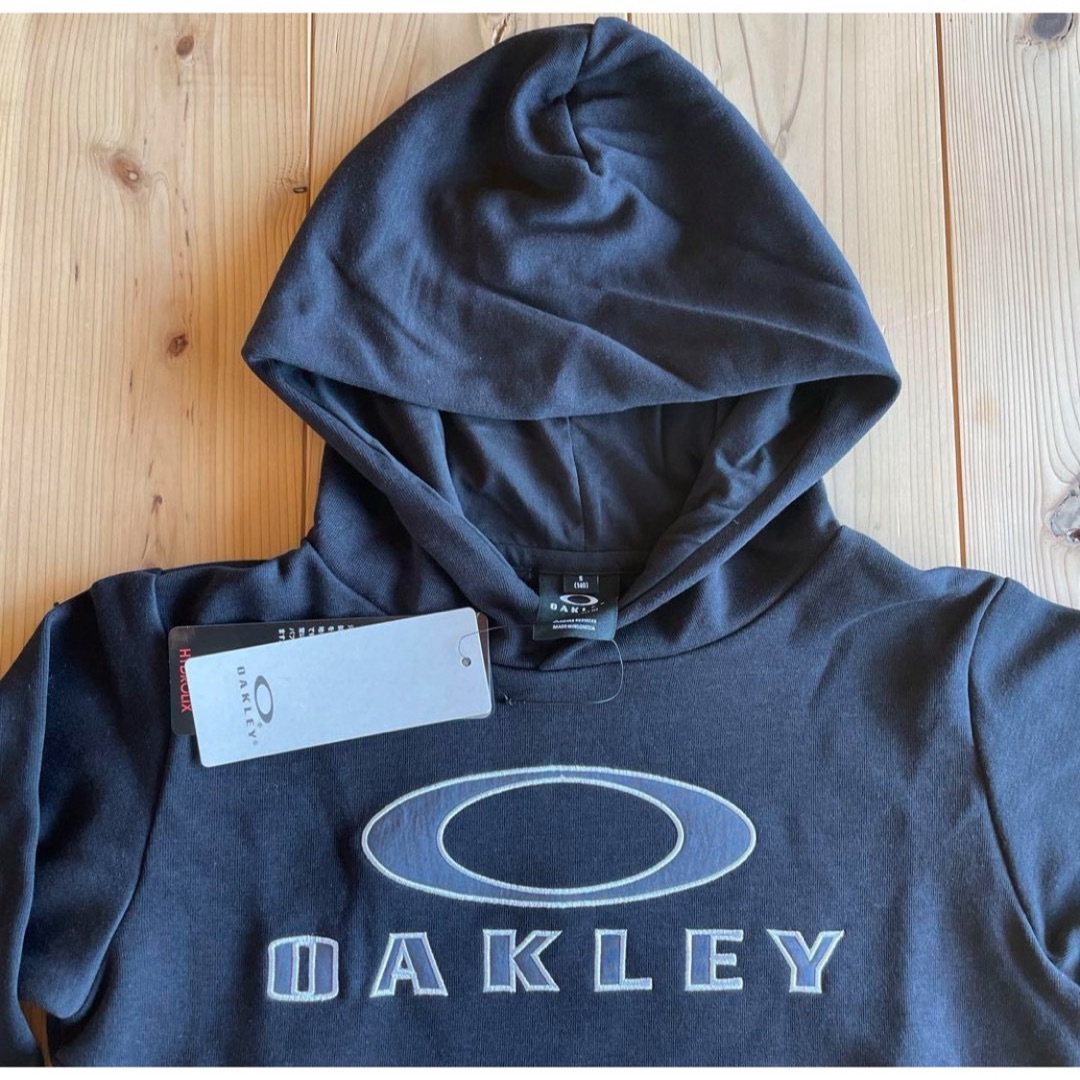 Oakley(オークリー)の新品　OAKLEYオークリー　フード付きパーカー　135-145㎝　ブラック キッズ/ベビー/マタニティのキッズ服男の子用(90cm~)(Tシャツ/カットソー)の商品写真