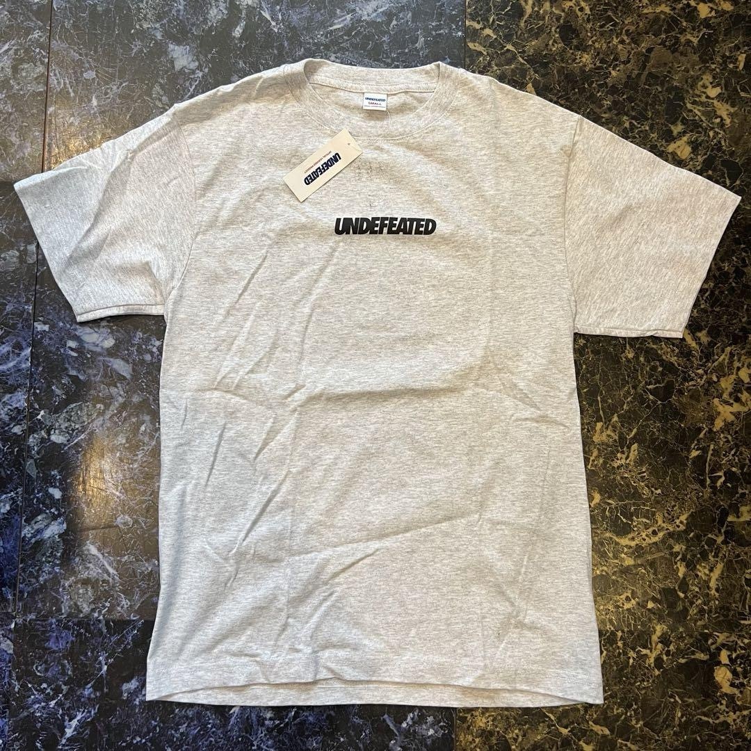 UNDEFEATED(アンディフィーテッド)のUNDEFEATED アンディフィーテッド　ロゴプリントTシャツ　半袖　グレー メンズのトップス(Tシャツ/カットソー(半袖/袖なし))の商品写真