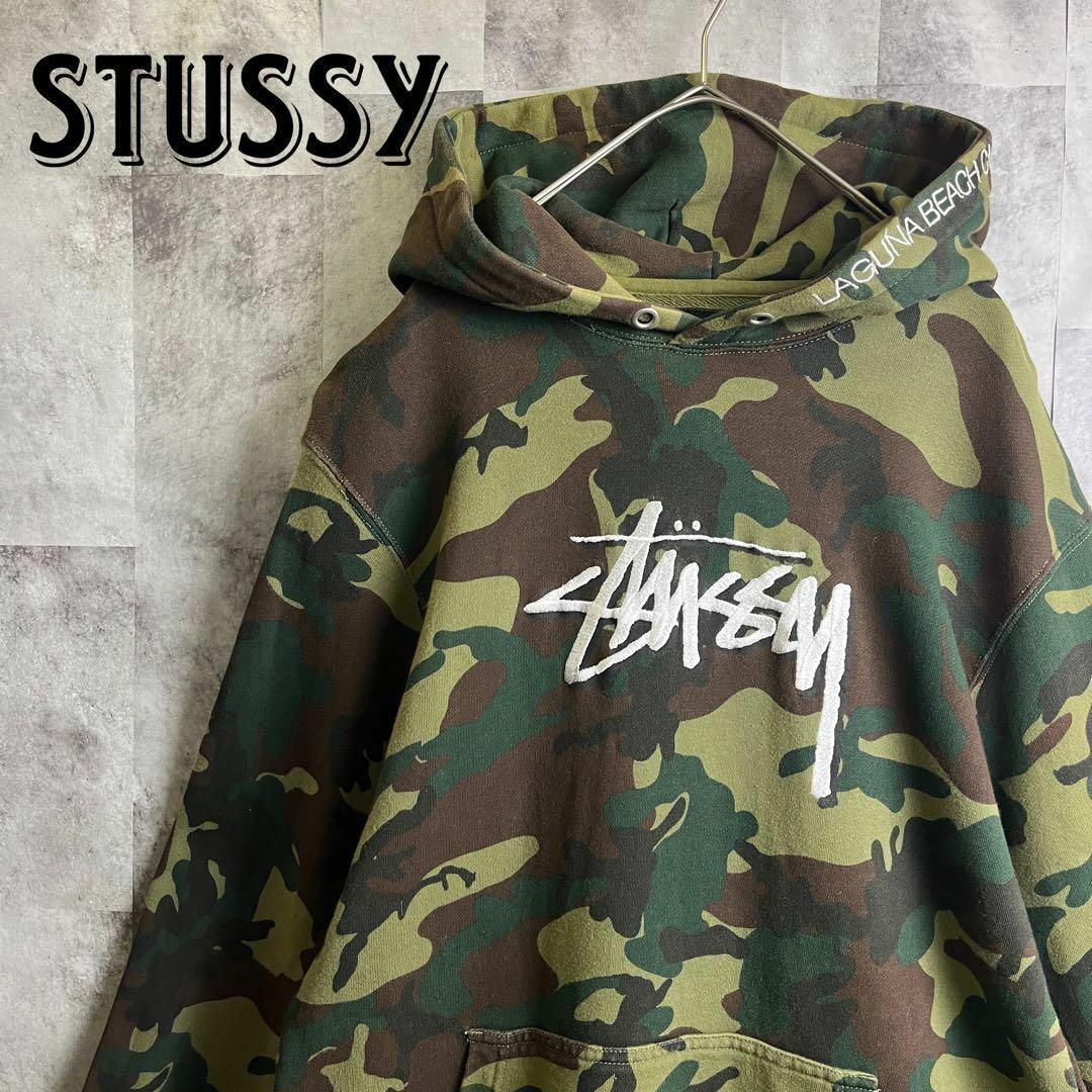 STUSSY(ステューシー)のステューシー プルオーバーパーカー カモフラ 刺繍センターロゴ フードロゴ M メンズのトップス(パーカー)の商品写真