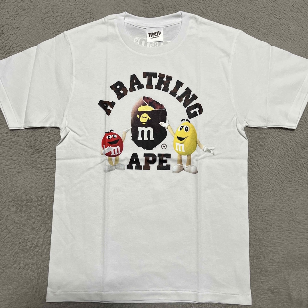 A BATHING APE(アベイシングエイプ)のAPE BAPE KAWS M&Ms COLLEGE LOGO tシャツ　s メンズのトップス(Tシャツ/カットソー(半袖/袖なし))の商品写真