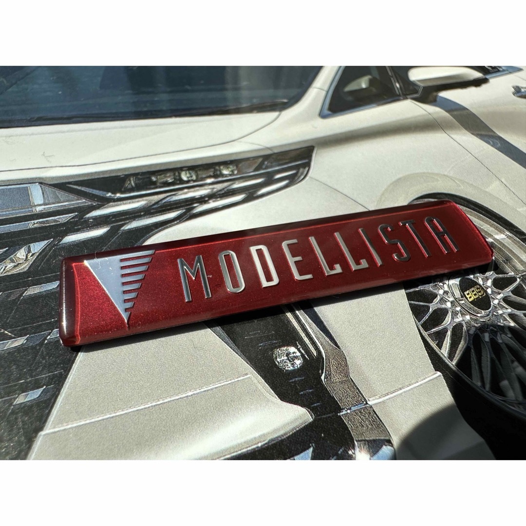 モデリスタスポイラーエンブレム加工品レッドメタリック 自動車/バイクの自動車(車外アクセサリ)の商品写真