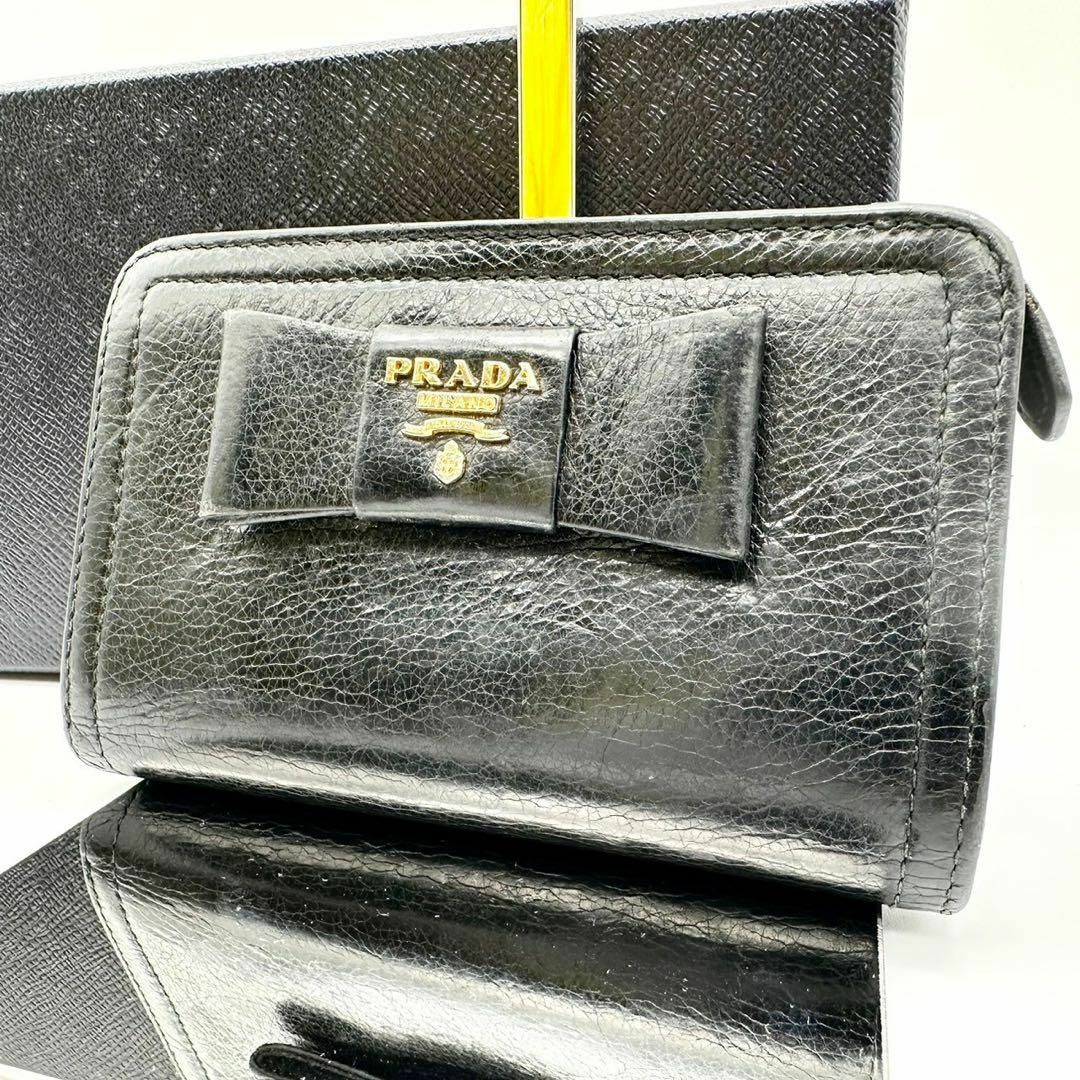 PRADA(プラダ)の【鑑定済】プラダ 二つ折り財布 ブラック リボン ゴールドロゴ レディース レディースのファッション小物(財布)の商品写真