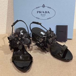 プラダ(PRADA)のPRADAのフラワービジュー付きエナメルブラックサンダル(サンダル)