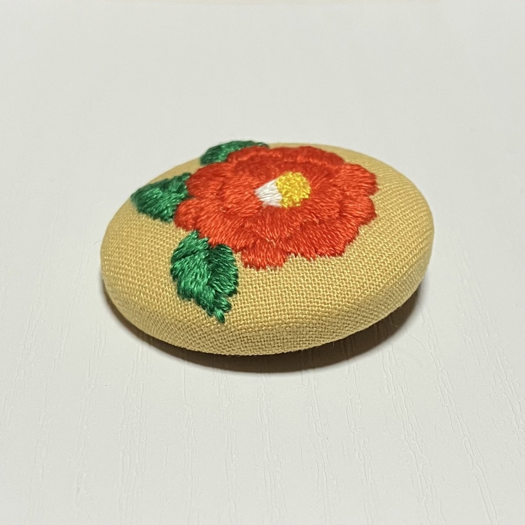 【C006】大きな椿の花刺繍ブローチ(ヘアゴム)  ハンドメイド くるみボタン レディースのアクセサリー(ブローチ/コサージュ)の商品写真