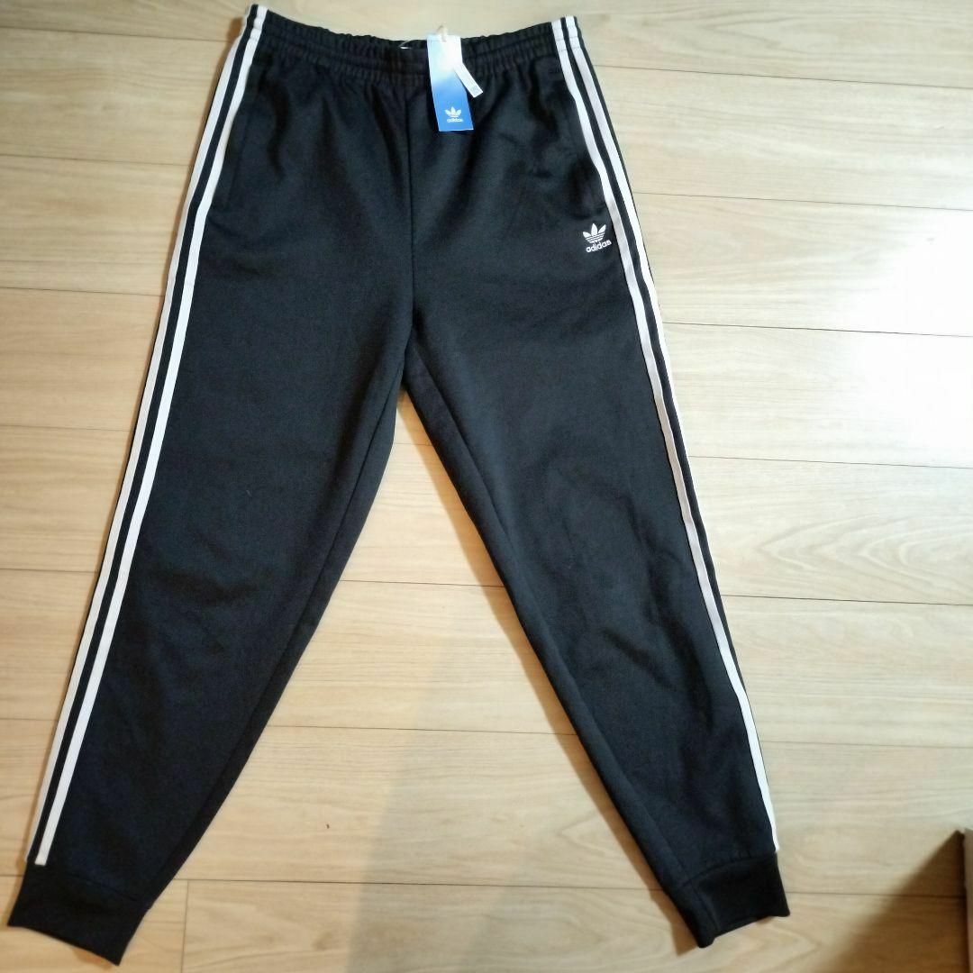 Originals（adidas）(オリジナルス)の新品 アディダス 黒 スーパースター トラックパンツ ジャージ カフ仕上 男性L メンズのパンツ(その他)の商品写真