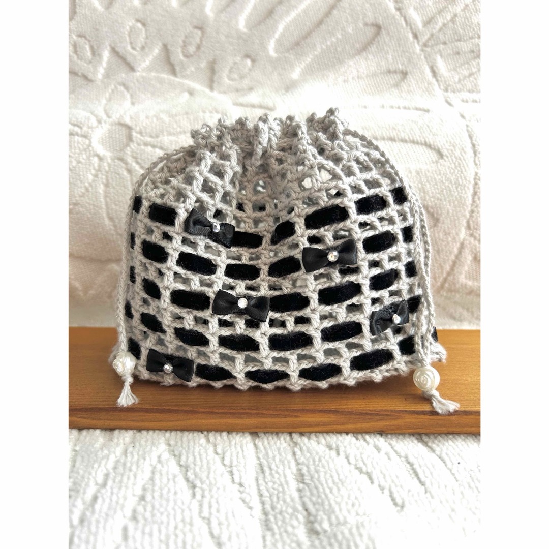 手編み巾着袋　リボン🎀　ポーチ　黒　ハンドメイド ハンドメイドのファッション小物(ポーチ)の商品写真