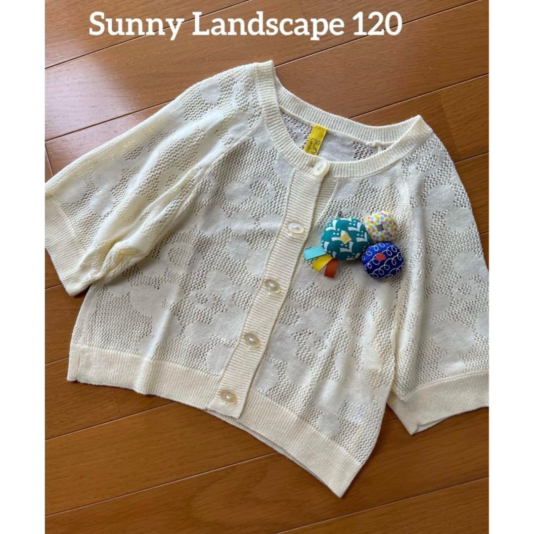 SunnyLandscape(サニーランドスケープ)のSunny Landscape  透かし編みカーディガン　コサージュ付　120 キッズ/ベビー/マタニティのキッズ服女の子用(90cm~)(カーディガン)の商品写真