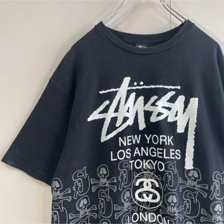 ステューシー(STUSSY)の【スカル、ワールドツアーロゴ】stussy両面プリント古着Tシャツ黒ストリート (Tシャツ/カットソー(半袖/袖なし))