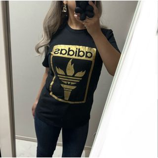 アディダス(adidas)のアディダス　聖火　オリンピック　ゴールド　ユニセックス　Tシャツ　レディース(Tシャツ/カットソー(半袖/袖なし))