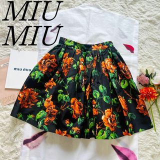 ミュウミュウ(miumiu)の【美品】MIU  MIU 総柄フレアスカート ブラック 花柄 オレンジ 36(ひざ丈スカート)