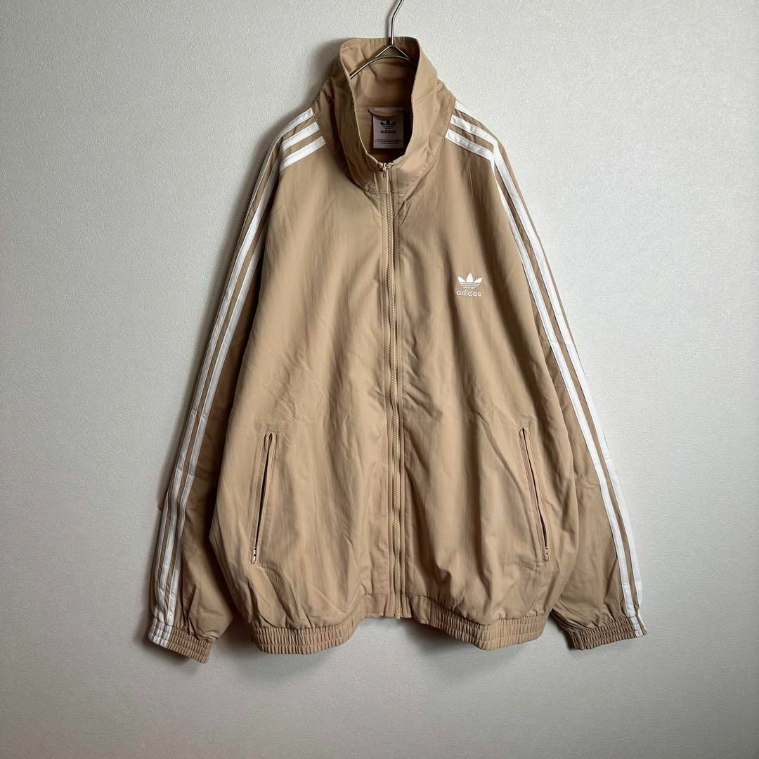 adidasウーブンファイヤーバード ナイロンジャケット ベージュ adidasウーブンファイヤーバード ナイロンジャケット ベージュ
